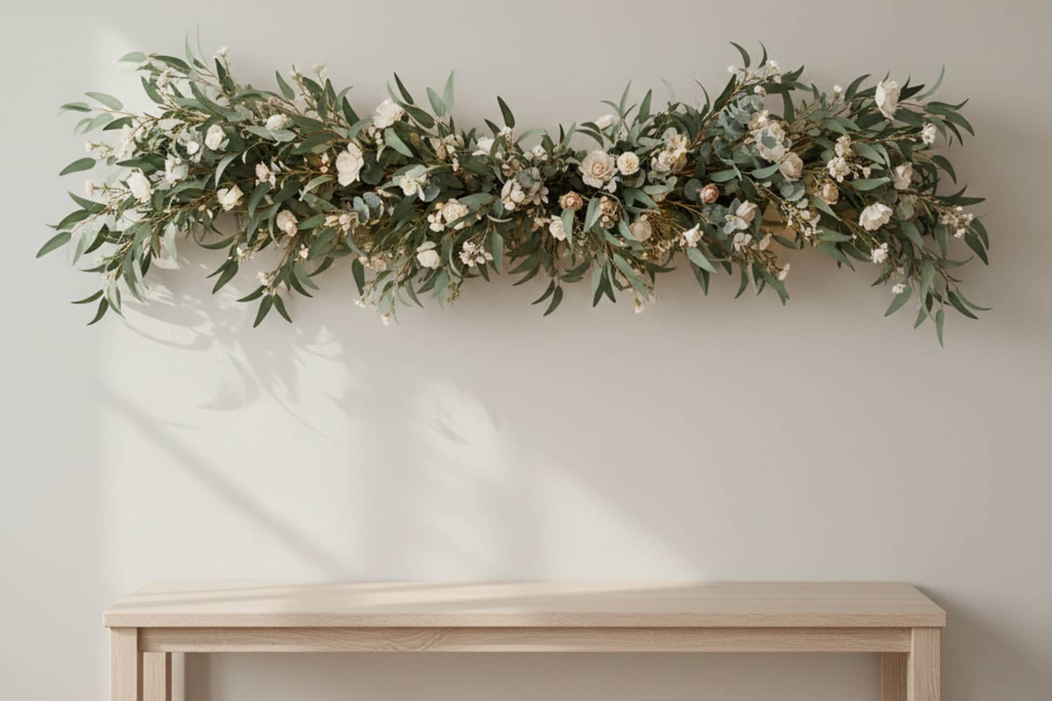 Floral garland with eucalyptus and soft flowers hanging above a console table